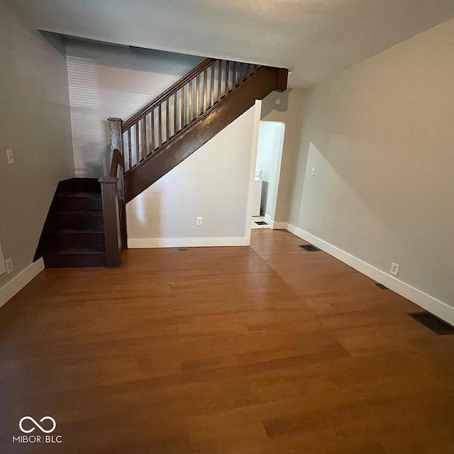 staircase with visible vents, baseboards, and wood finished floors