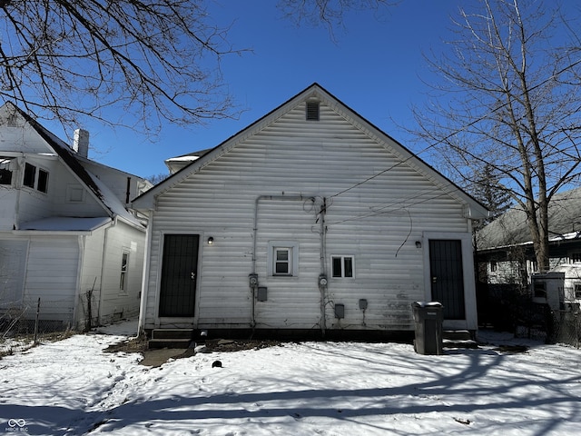 view of snow covered back of property