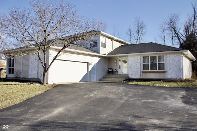 view of front of house featuring stone siding, roof with shingles, driveway, and an attached garage