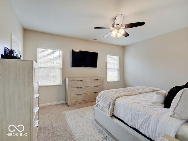 bedroom featuring baseboards, visible vents, a ceiling fan, and light colored carpet