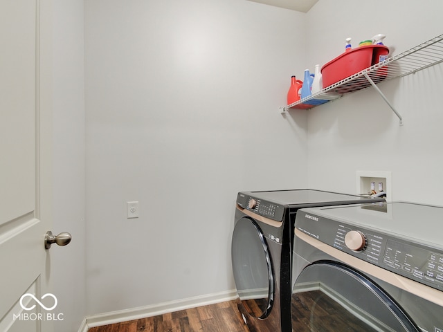 laundry room featuring laundry area, washer and clothes dryer, wood finished floors, and baseboards