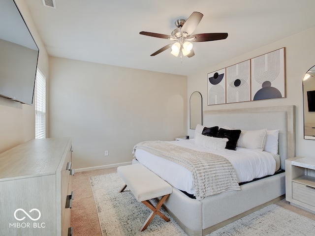 bedroom featuring ceiling fan, visible vents, baseboards, and light colored carpet