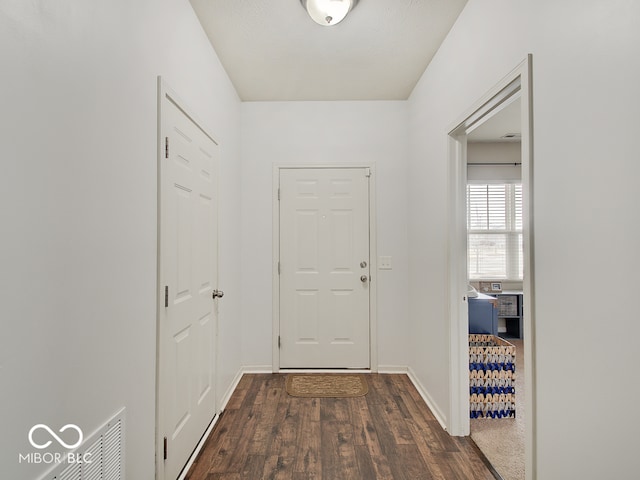 interior space with baseboards and dark wood-type flooring