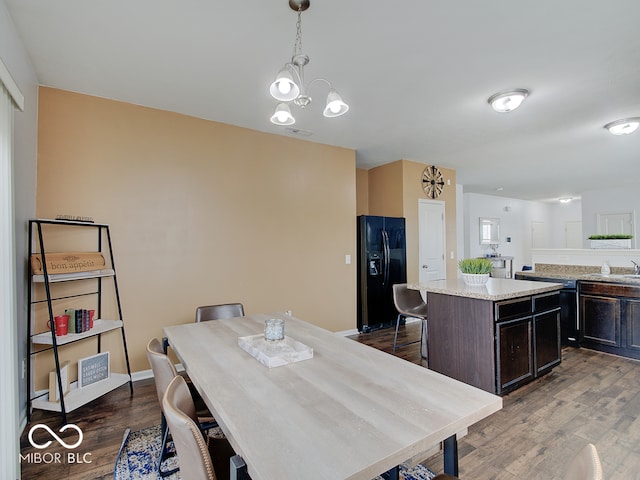 dining area featuring dark wood-style floors, a chandelier, visible vents, and baseboards