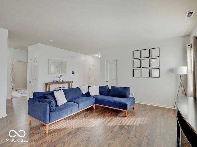 living area with visible vents, baseboards, and wood finished floors