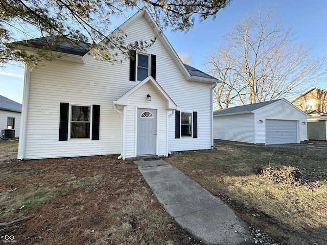 view of front of property featuring a garage, an outdoor structure, and central AC unit