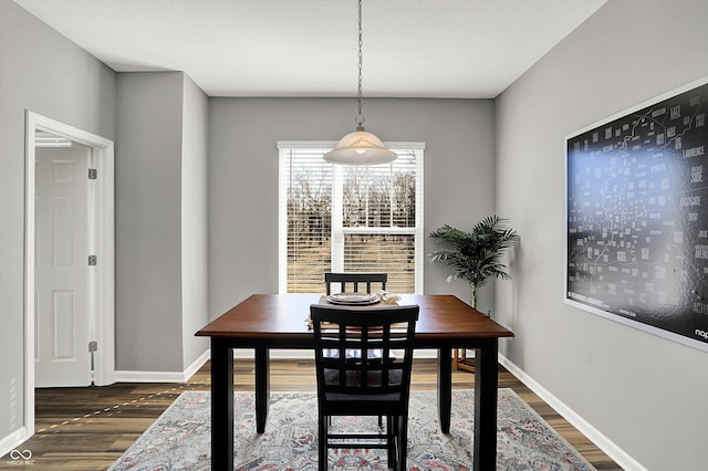 dining space featuring dark wood finished floors and baseboards