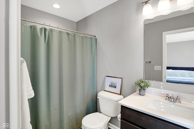 ensuite bathroom featuring ensuite bathroom, toilet, and vanity