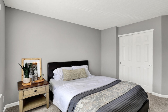 bedroom with baseboards, light carpet, and a closet