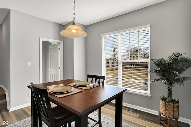 dining area with stairway, visible vents, baseboards, and wood finished floors