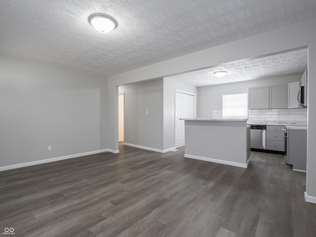 interior space with dark wood-style floors, a textured ceiling, and baseboards