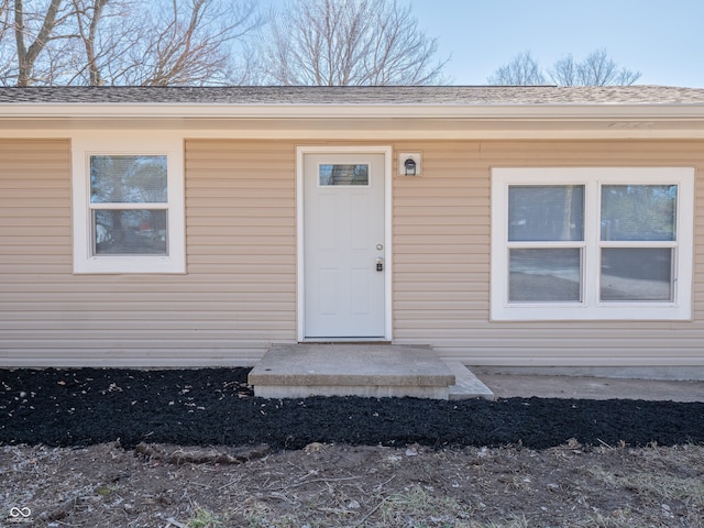 property entrance featuring a shingled roof