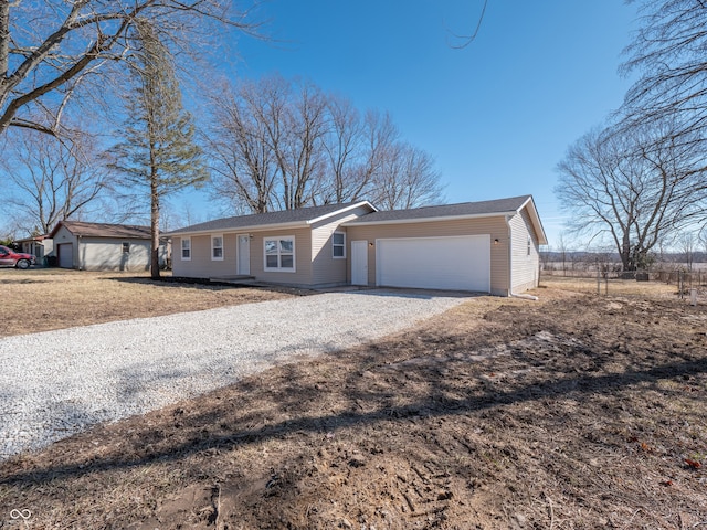 ranch-style home featuring gravel driveway and an attached garage