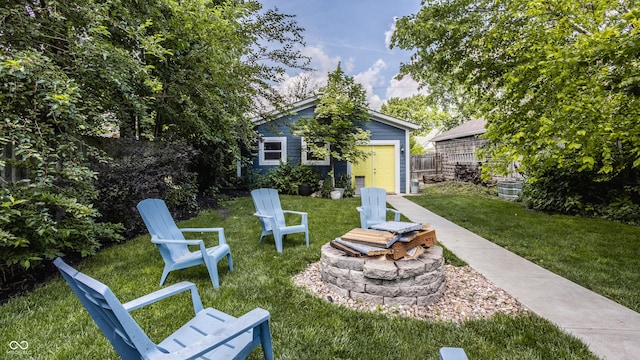 view of yard with an outbuilding, fence, and a fire pit