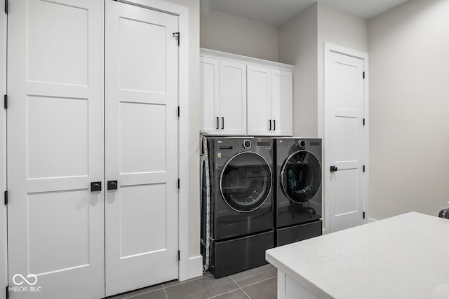 washroom featuring cabinet space, tile patterned floors, and washing machine and dryer