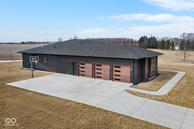 view of property exterior featuring a lawn, roof with shingles, and driveway