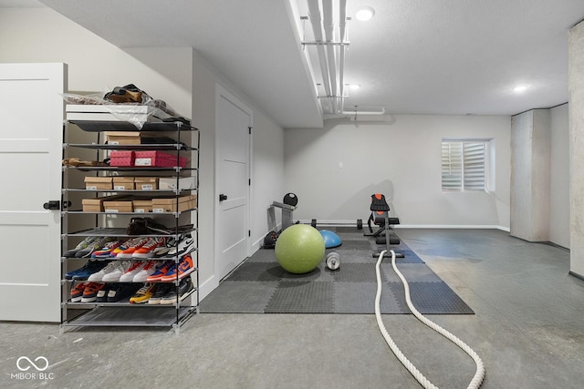 workout area featuring recessed lighting and baseboards