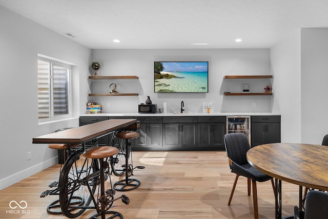 bar featuring recessed lighting, wet bar, wine cooler, and baseboards