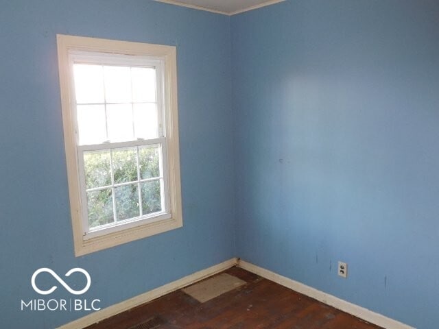 empty room with dark wood finished floors and baseboards