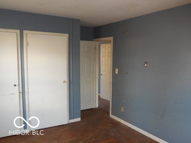 unfurnished bedroom featuring wood finished floors and baseboards