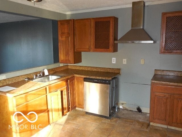 kitchen featuring stainless steel dishwasher, brown cabinetry, a sink, wall chimney range hood, and a textured ceiling