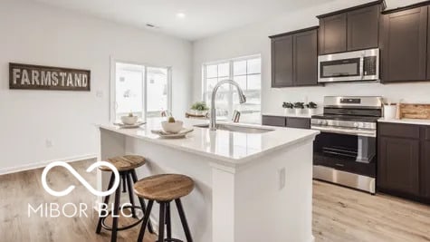 kitchen with a breakfast bar, a sink, light countertops, appliances with stainless steel finishes, and light wood finished floors