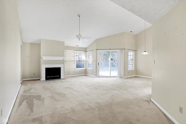 unfurnished living room with a textured ceiling, a tiled fireplace, carpet, and baseboards