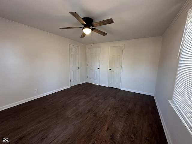 unfurnished bedroom with dark wood-style floors, ceiling fan, crown molding, and baseboards