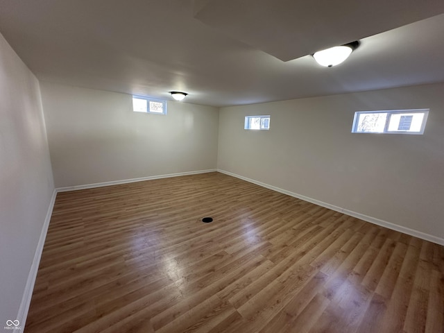 basement with baseboards and wood finished floors