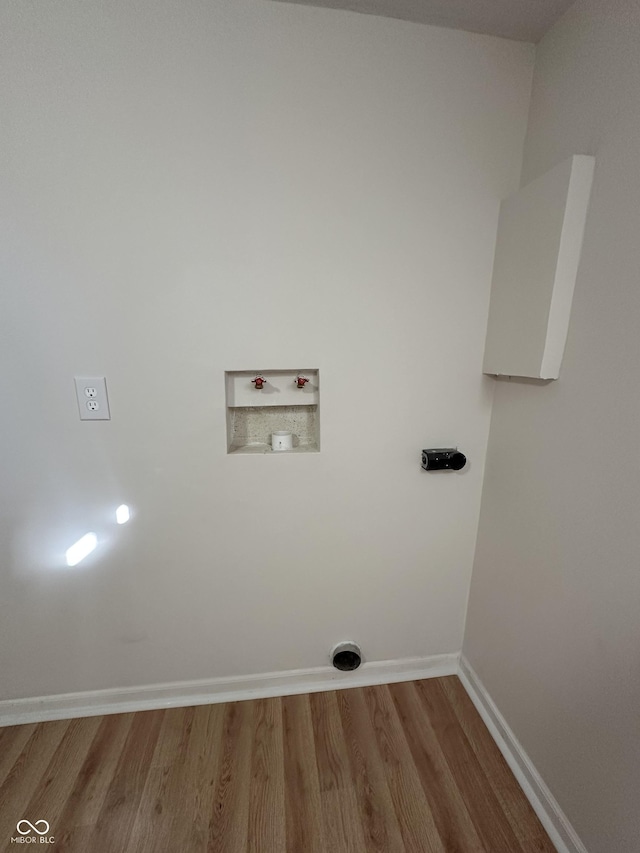 laundry room with washer hookup, laundry area, baseboards, and wood finished floors