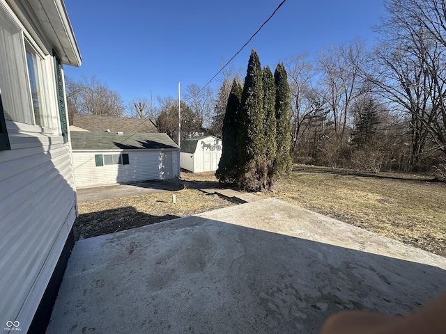 view of yard with an outbuilding, a patio area, and a storage shed