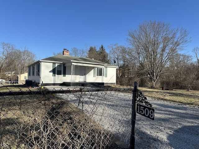 view of front facade featuring a fenced front yard and a chimney