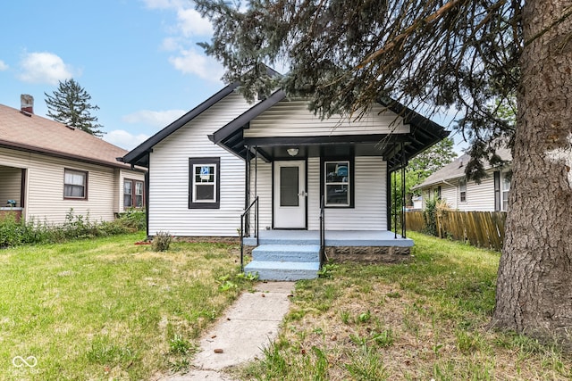 bungalow-style home with fence, a porch, and a front yard