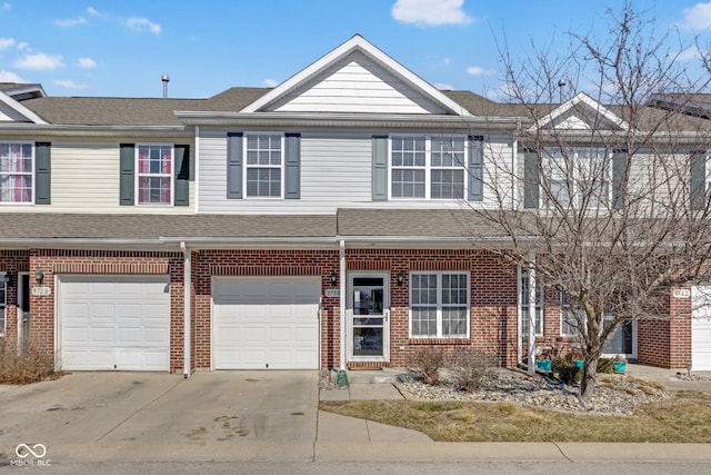 multi unit property featuring driveway, roof with shingles, a garage, and brick siding