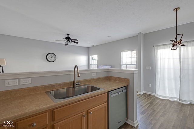 kitchen with ceiling fan, a textured ceiling, light wood-style flooring, a sink, and dishwasher