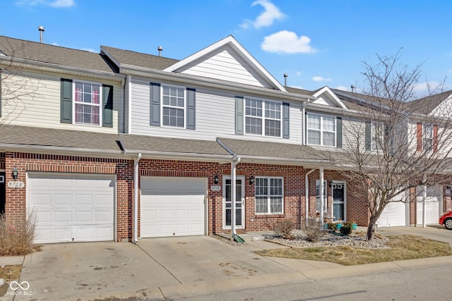 townhome / multi-family property with a garage, driveway, brick siding, and roof with shingles