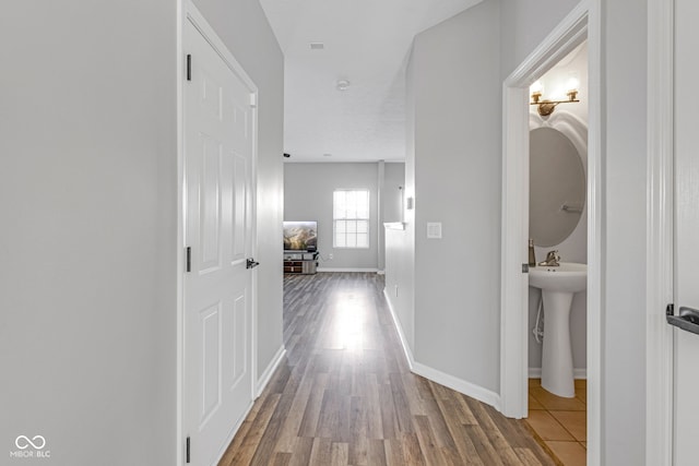 hall featuring wood finished floors and baseboards