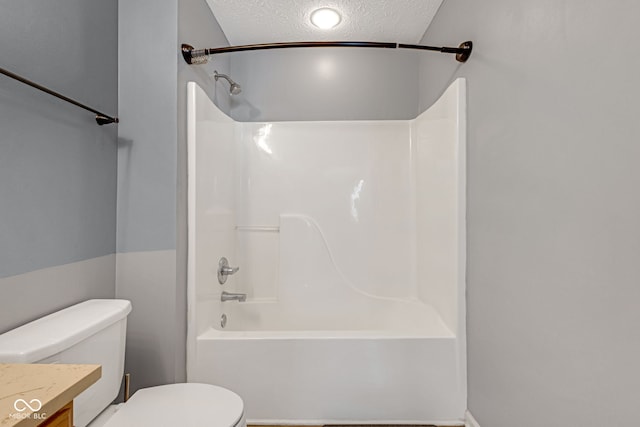 full bathroom featuring a textured ceiling, shower / tub combination, vanity, and toilet