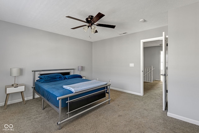 carpeted bedroom featuring a ceiling fan, baseboards, visible vents, and a textured ceiling