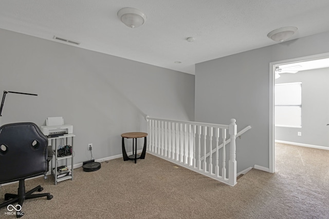 office featuring a textured ceiling, carpet, visible vents, and baseboards