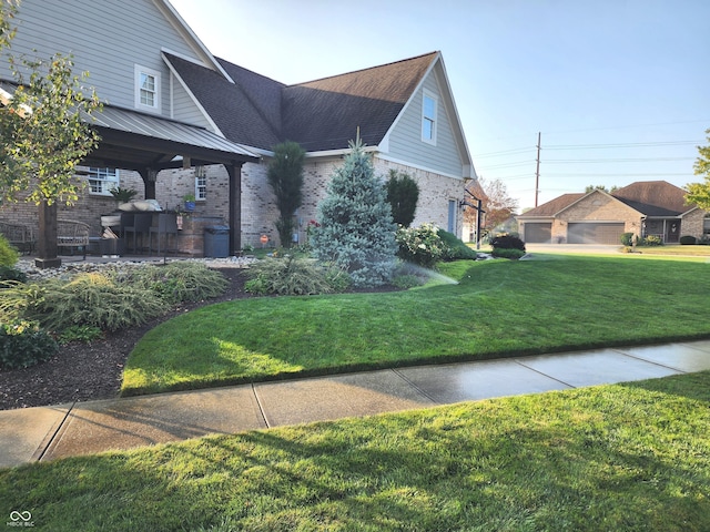 view of front of home with a front yard, brick siding, and a gazebo