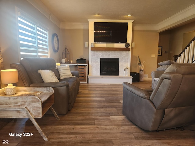 living area featuring a fireplace, crown molding, and wood finished floors