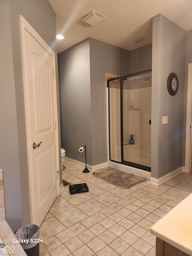 full bath with toilet, a stall shower, visible vents, and tile patterned floors