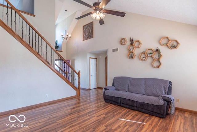 living room featuring baseboards, stairs, visible vents, and wood finished floors