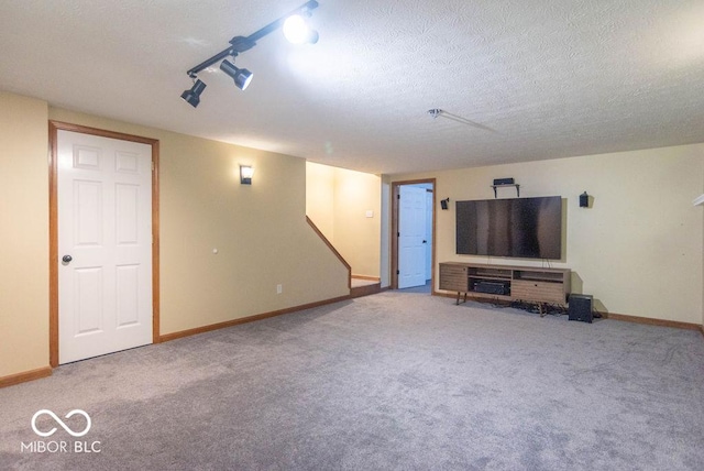 unfurnished living room featuring carpet flooring, a textured ceiling, and baseboards