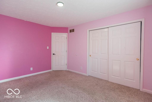 unfurnished bedroom with a closet, carpet flooring, visible vents, and baseboards