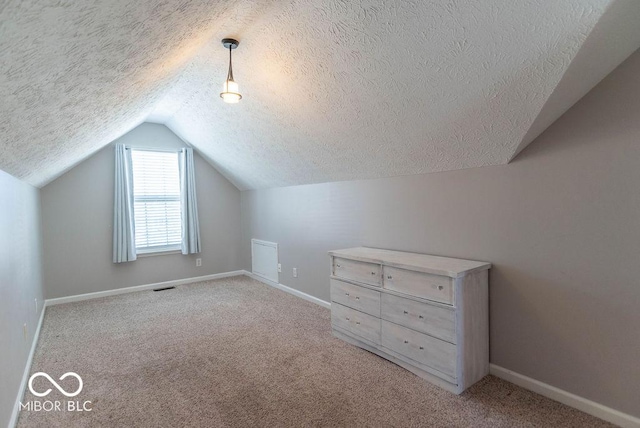 additional living space featuring light colored carpet, visible vents, vaulted ceiling, and baseboards