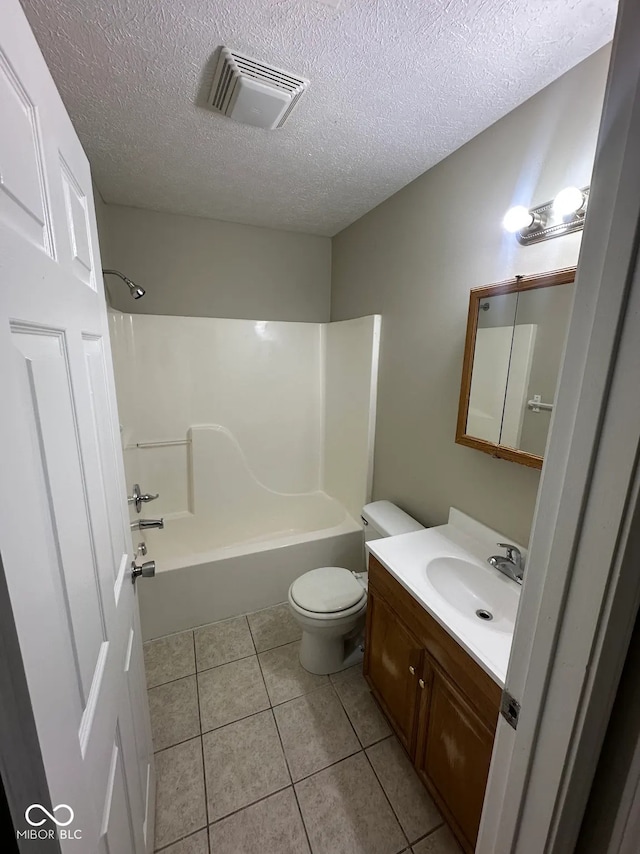 bathroom with visible vents, vanity, toilet, a textured ceiling, and tile patterned floors