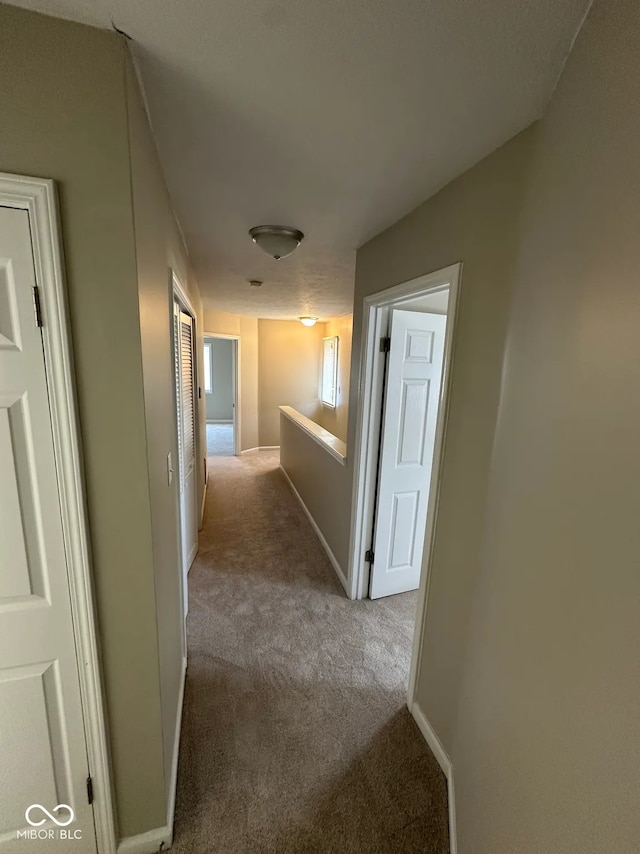 hall with carpet flooring and baseboards