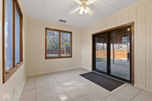 interior space with a ceiling fan, a wealth of natural light, visible vents, and light tile patterned flooring